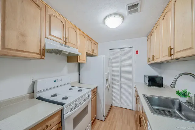 a kitchen with stainless steel appliances granite countertop a refrigerator a stove and a wooden floors