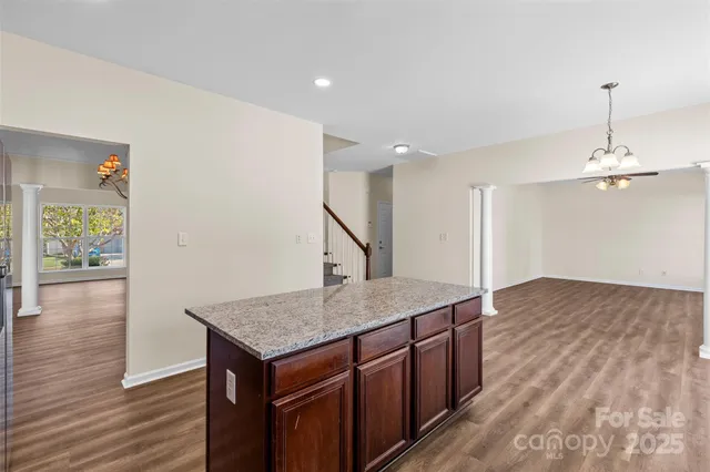 a kitchen with a wooden floor and a chandelier
