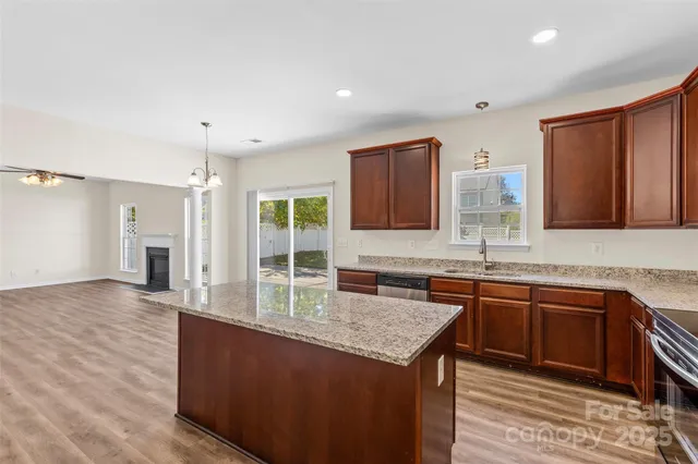 a kitchen with stainless steel appliances granite countertop a sink stove and cabinets