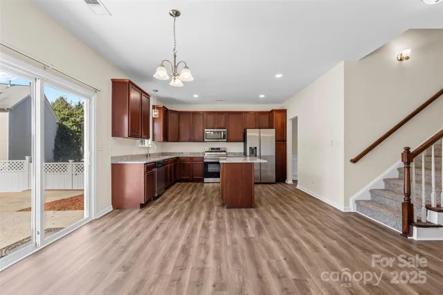 a large kitchen with granite countertop a large counter top stainless steel appliances and cabinets