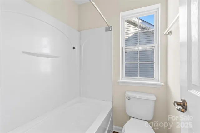 a white toilet sitting next to a bath tub