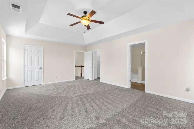 a view of a big room with wooden floor and chandelier fan