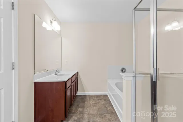 a en suite bathroom with a double vanity sink a mirror and a shower