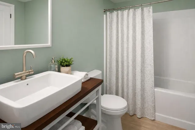 a bathroom with a sink a toilet and shower curtain