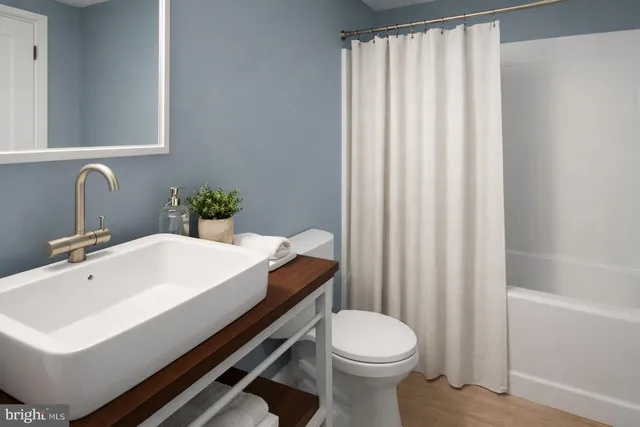 a bathroom with a sink a toilet and shower curtain