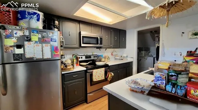 a kitchen with stainless steel appliances granite countertop a refrigerator a sink dishwasher and a stove with wooden floor