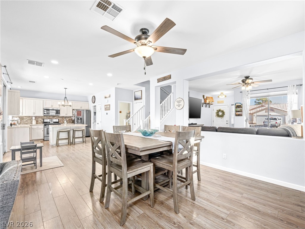 2199 Maple Shade Street Henderson, NV 89002 - Photo 13 of 75 Dining space with baseboards, wood Living area with baseboards, a stone fireplace, and luxury vinyl plank flooring