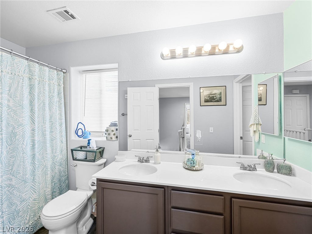 2199 Maple Shade Street Henderson, NV 89002 - Photo 28 of 75 Full bathroom featuring a double vanity, toilet, tub/shower combo, and luxury vinyl plank flooring.