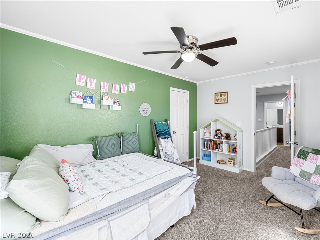 2199 Maple Shade Street Henderson, NV 89002 - Photo 31 of 75 Bedroom 3 offers carpet flooring, a ceiling fan, baseboards, and decorative molding accents.