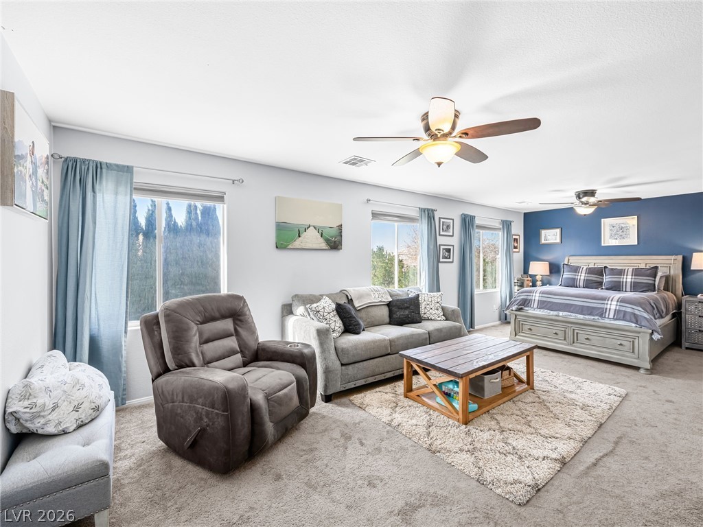 2199 Maple Shade Street Henderson, NV 89002 - Photo 32 of 75 Primary bedroom suite featuring carpeted flooring, baseboards, and a custom barn door leading to the ensuite. This massive, private suite includes a dedicated living area, bedroom, and ensuite bathroom, creating a separate wing for added privacy and comfort.