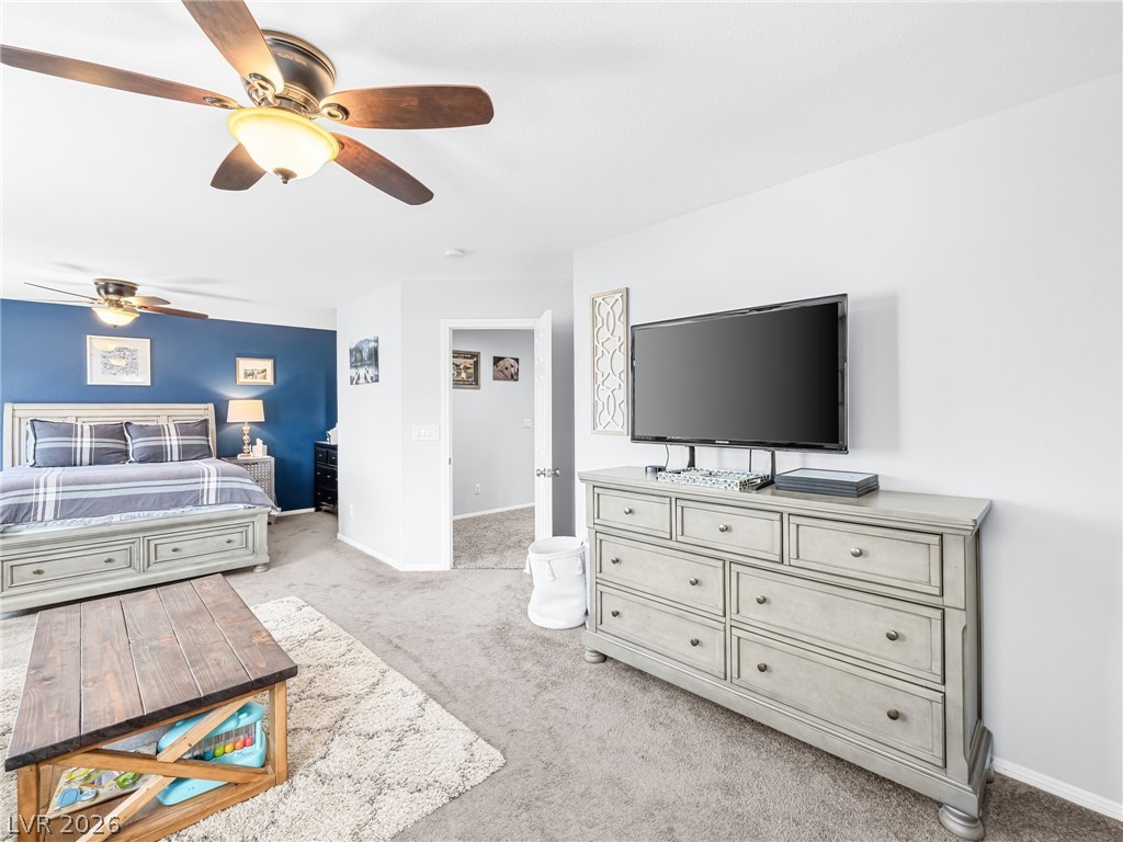 2199 Maple Shade Street Henderson, NV 89002 - Photo 33 of 75 Primary bedroom suite featuring carpeted flooring, baseboards, and a custom barn door leading to the ensuite. This massive, private suite includes a dedicated living area, bedroom, and ensuite bathroom, creating a separate wing for added privacy and comfort.