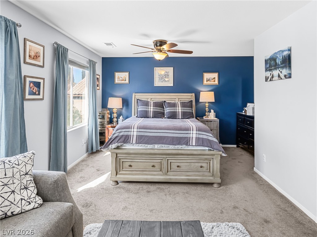 2199 Maple Shade Street Henderson, NV 89002 - Photo 34 of 75 Primary bedroom suite featuring carpeted flooring, baseboards, and a custom barn door leading to the ensuite. This massive, private suite includes a dedicated living area, bedroom, and ensuite bathroom, creating a separate wing for added privacy and comfort.