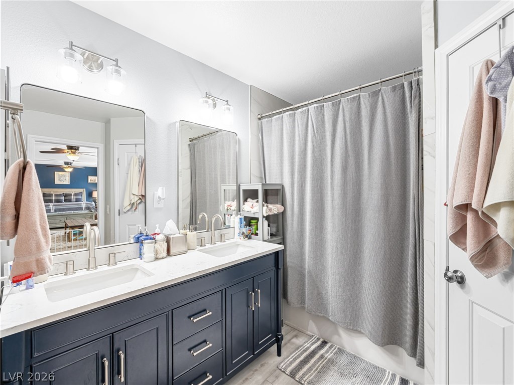 2199 Maple Shade Street Henderson, NV 89002 - Photo 37 of 75 Bathroom featuring custom double vanity with dual sinks, LVP flooring, expansive walk-in closet, and a separate water closet and upgraded tiled surround tub/shower combo.