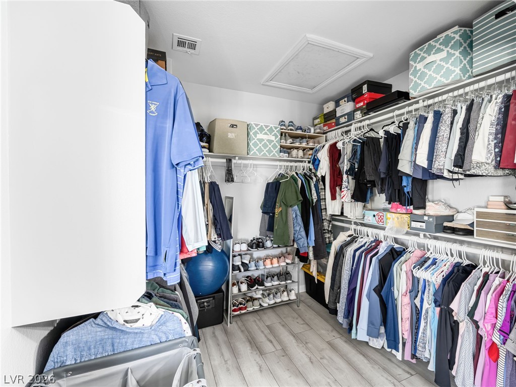 2199 Maple Shade Street Henderson, NV 89002 - Photo 38 of 75 Bathroom featuring custom double vanity with dual sinks, LVP flooring, expansive walk-in closet, and a separate water closet and upgraded tiled surround tub/shower combo.