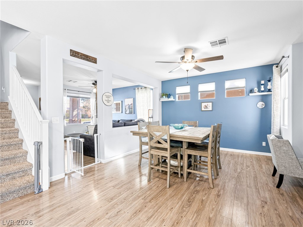 2199 Maple Shade Street Henderson, NV 89002 - Photo 9 of 75 Dining space with baseboards, wood Living area with baseboards, a stone fireplace, and luxury vinyl plank flooring