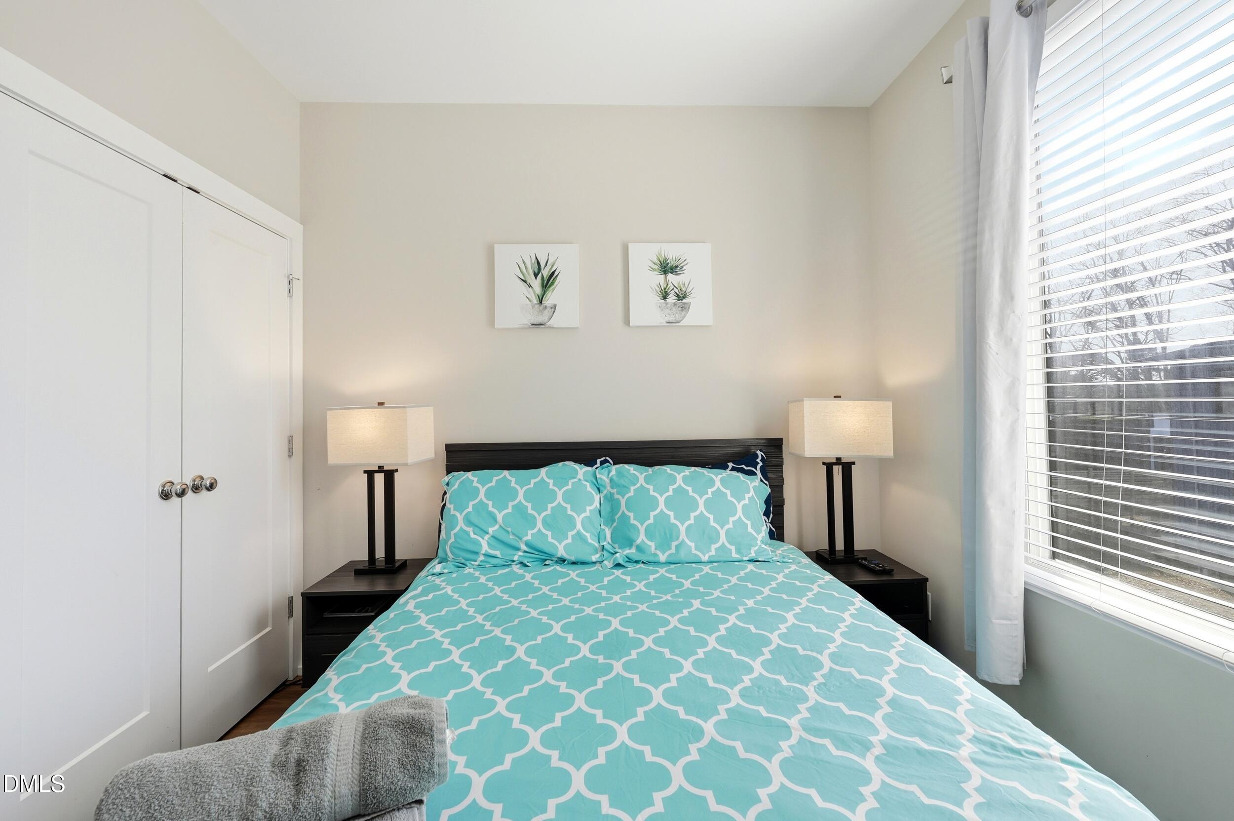 3138 Rowena Avenue Durham, NC 27703 - Photo 18 of 31 a bedroom with a bed and a lamp on table