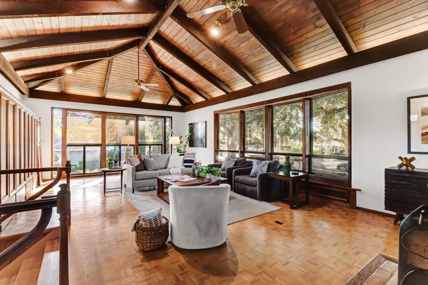 a living room with furniture large windows wooden floor and furniture