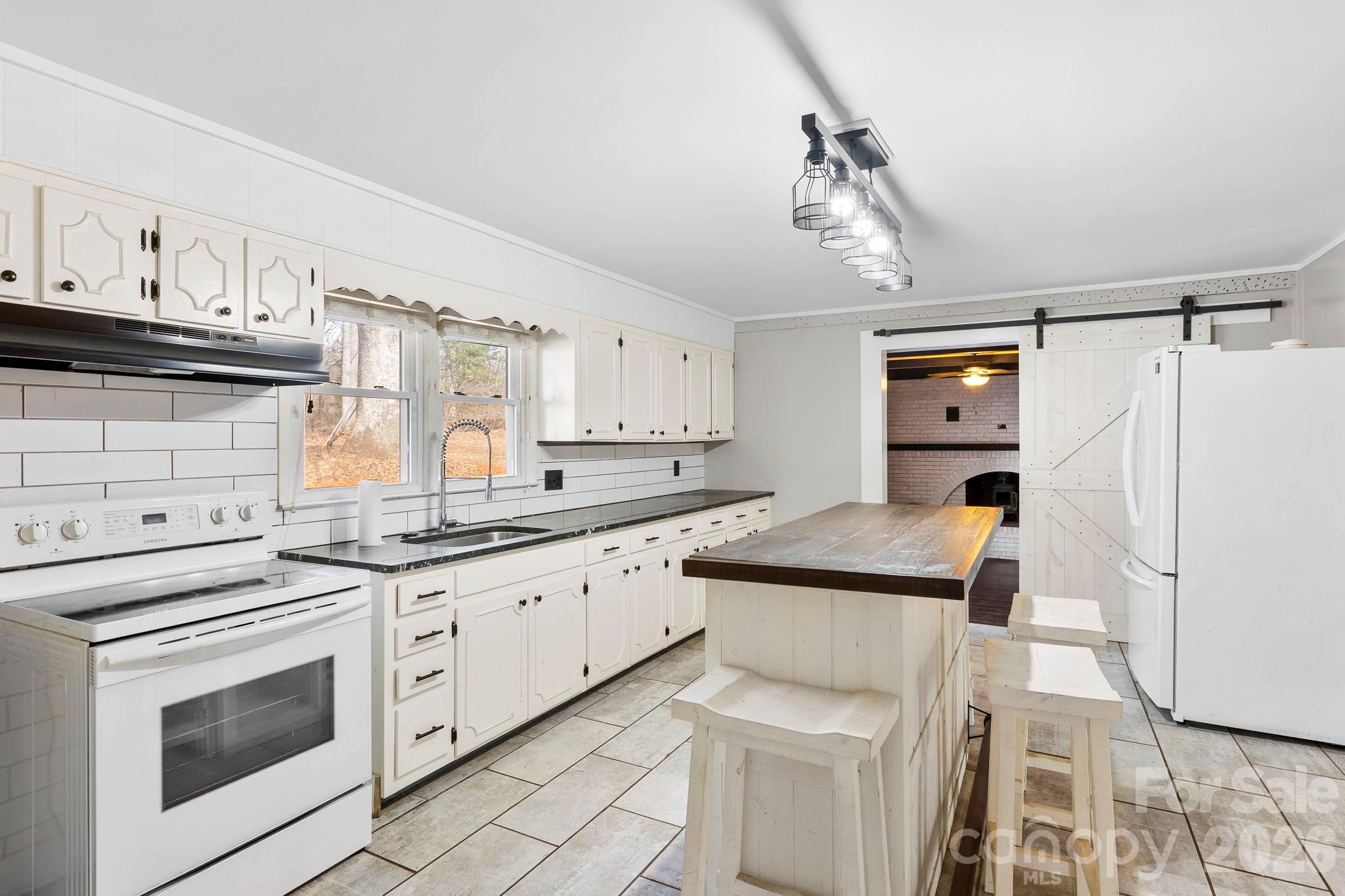 42 Old Patton Hill Road Swannanoa, NC 28778 - Photo 8 of 33 a kitchen with granite countertop white cabinets and white appliances