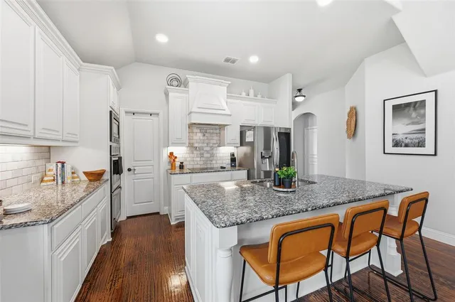 a kitchen with a center island appliances and a large window