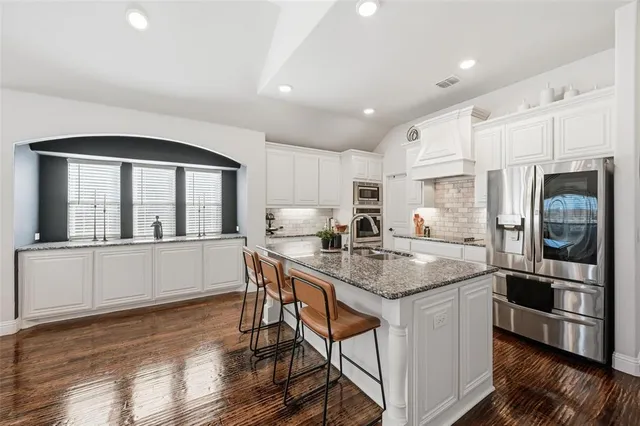 a kitchen with sink stove and cabinets
