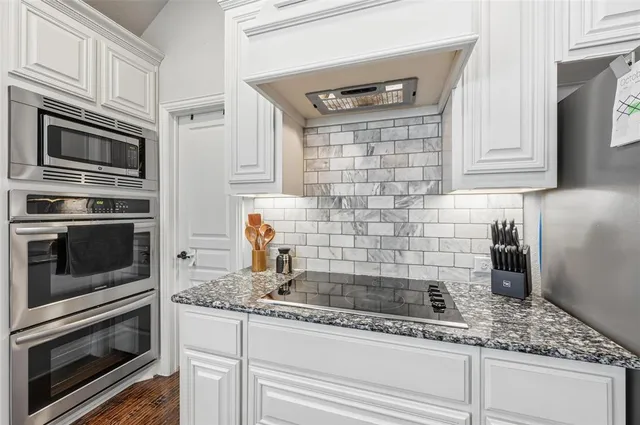 a kitchen with stainless steel appliances granite countertop a sink and a stove