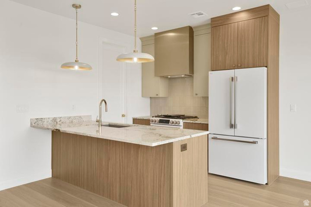 990 Manen Street Washington, UT 84780 - Photo 6 of 43 Modern kitchen featuring a central island with a sink, light-toned wood-finish cabinetry, and light-colored countertops