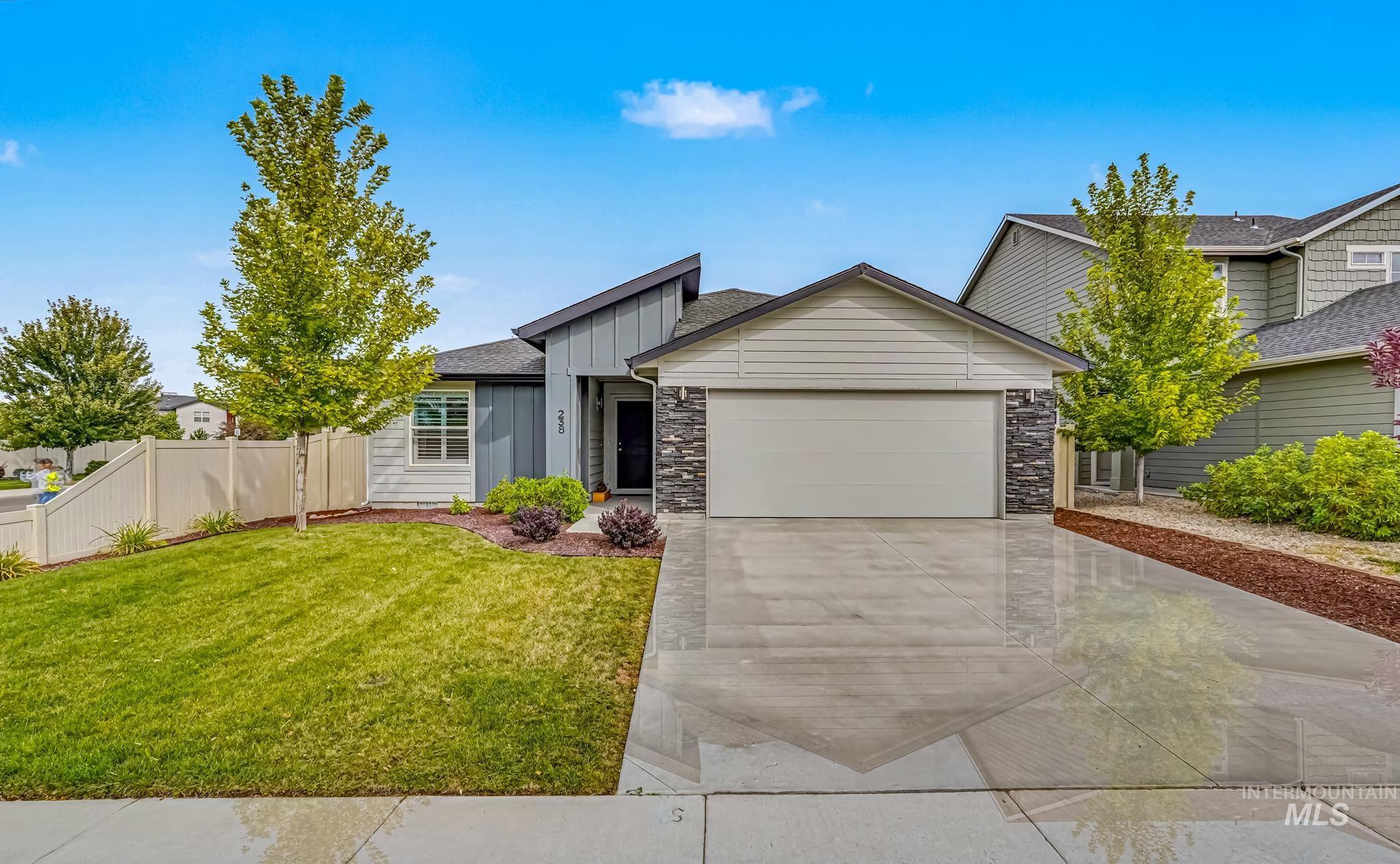 238 West Riggs Spring Avenue Meridian, ID 83642 - Photo 1 of 16 Contemporary exterior with vertical and horizontal siding, stone accents, attached two-car garage, concrete driveway, and established front landscaping
