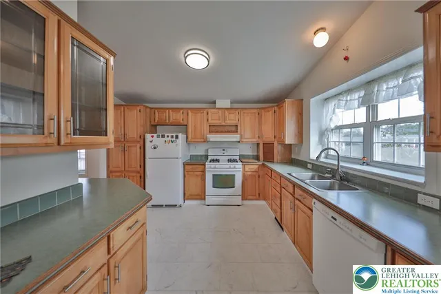 a kitchen with stainless steel appliances granite countertop a sink counter space cabinets and a large window