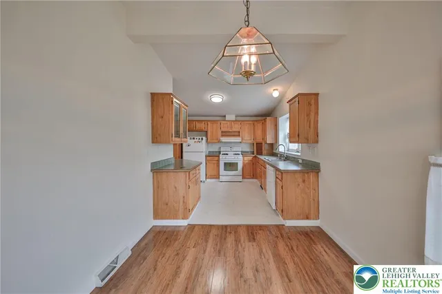 a view of a kitchen with wooden floor and electronic appliances
