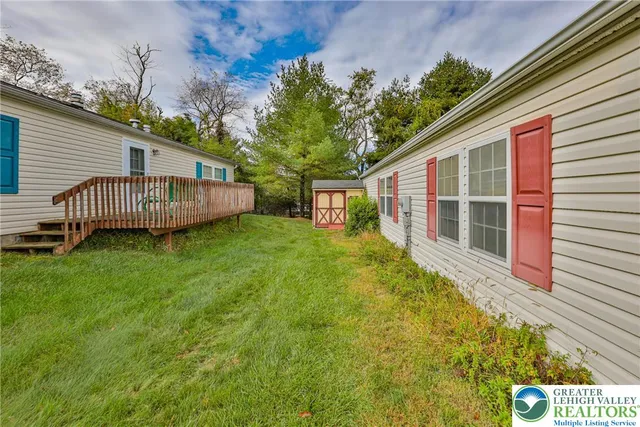 a view of a house with a backyard and wooden fence