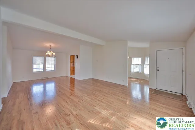 a view of empty room with wooden floor and window