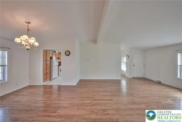 a view of a room with wooden floor and chandelier