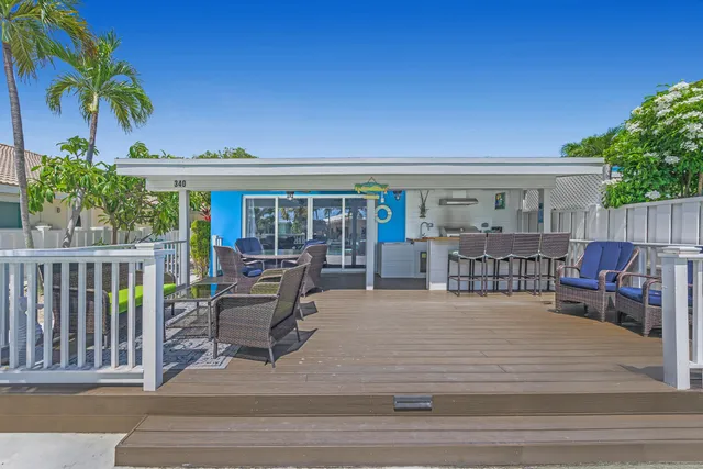 a view of a house with wooden deck and furniture