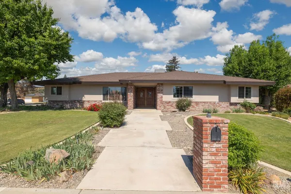 a front view of house with yard and green space