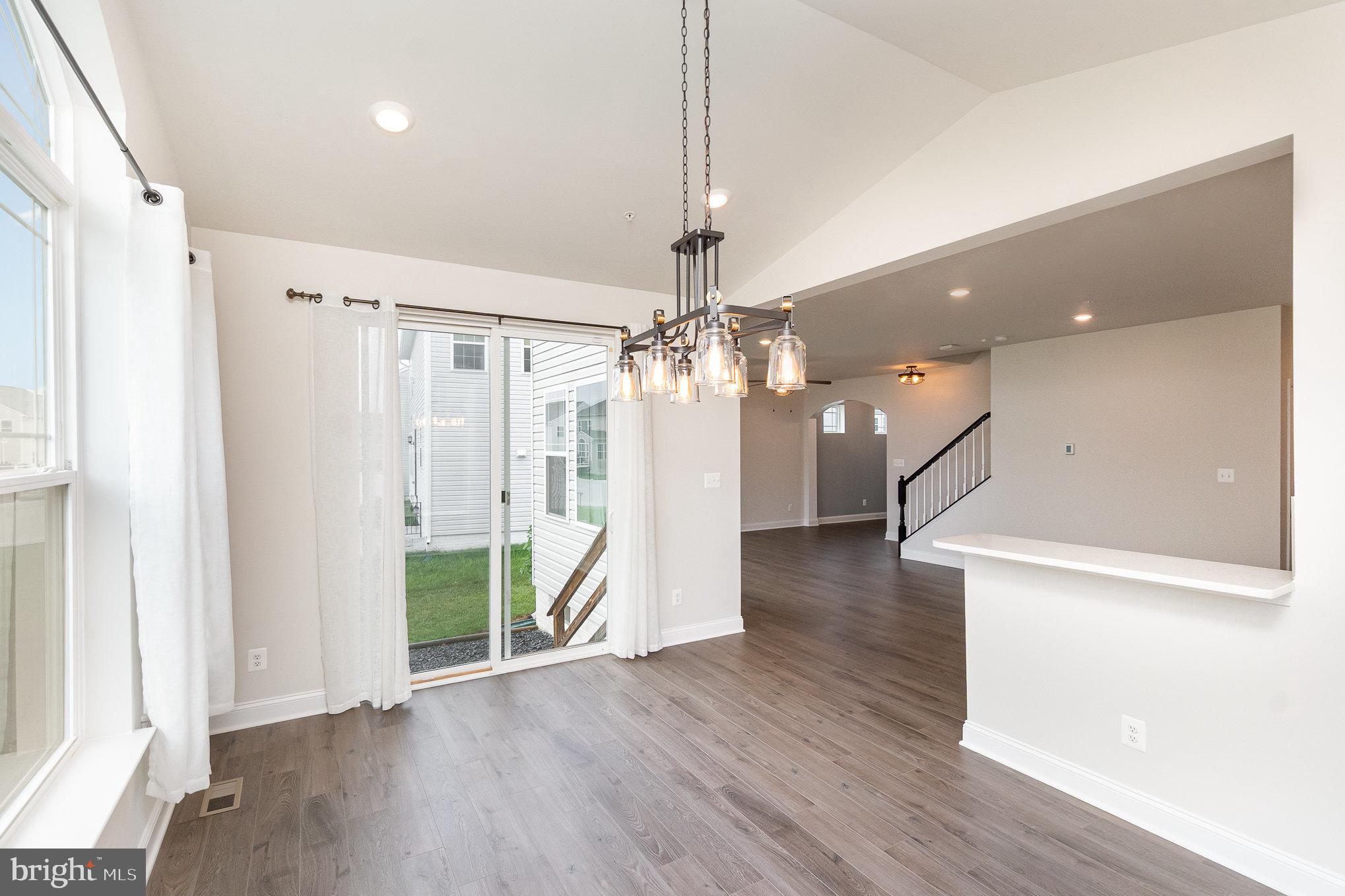 1126 Up And Over Lane Aberdeen, MD 21001 - Photo 13 of 46 a view of a livingroom with wooden floor staircase and a kitchen space