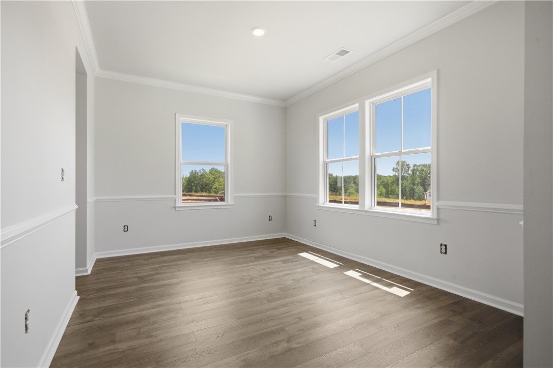 552 Hydrangea Street, Unit LOT 66 Seneca, SC 29678 - Photo 5 of 31 Hardwood flooring extends throughout this versatile, well-lit room, featuring multiple windows and crown molding.