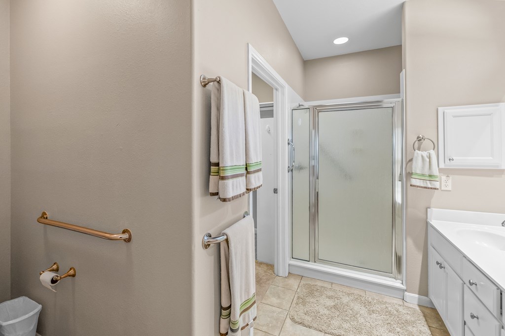 225 Los Cedros Loop Kerrville, TX 78028 - Photo 10 of 27 a bathroom with a granite countertop shower mirror and toilet