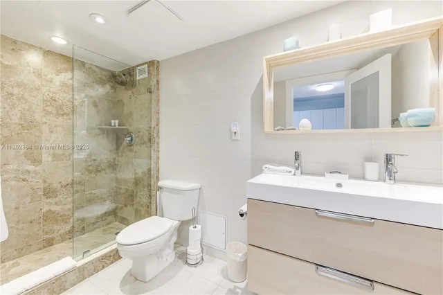 a bathroom with a sink toilet a mirror and shower