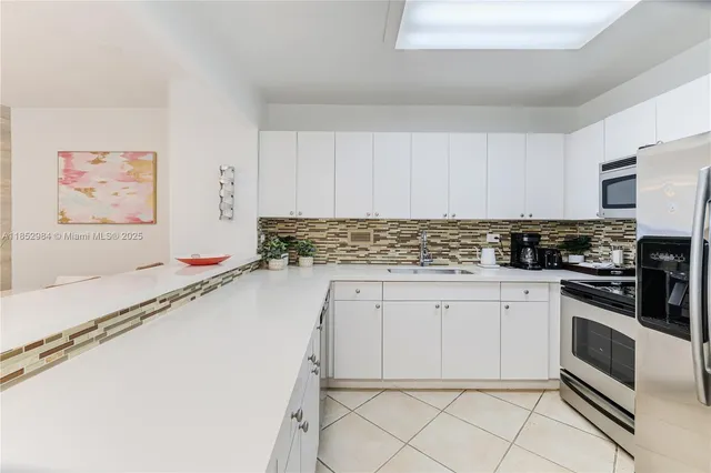 a kitchen with granite countertop white cabinets and stainless steel appliances