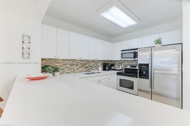a kitchen with granite countertop stainless steel appliances and white cabinets