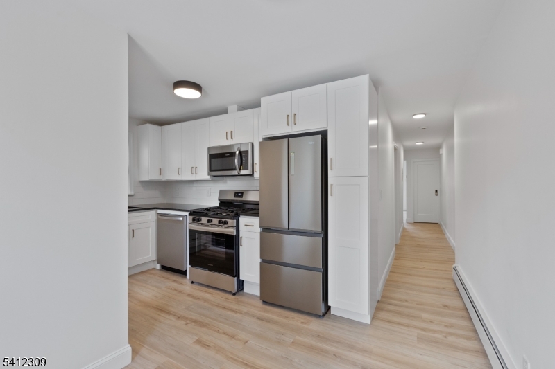 676 Chestnut Street, Unit 1 Kearny, NJ 07032 - Photo 12 of 27 a kitchen with cabinets and stainless steel appliances