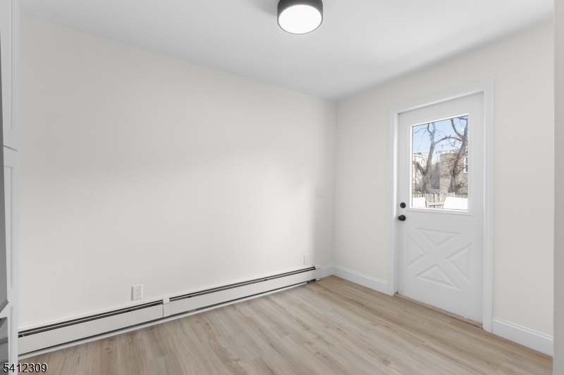 676 Chestnut Street, Unit 1 Kearny, NJ 07032 - Photo 19 of 27 a view of an empty room with wooden floor and a window