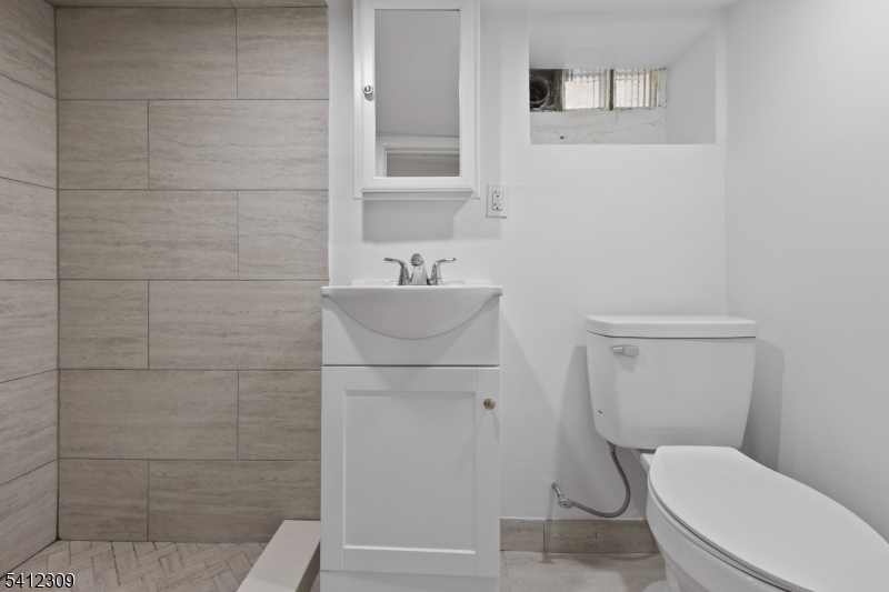 676 Chestnut Street, Unit 1 Kearny, NJ 07032 - Photo 27 of 27 a white toilet sitting next to a bathroom sink
