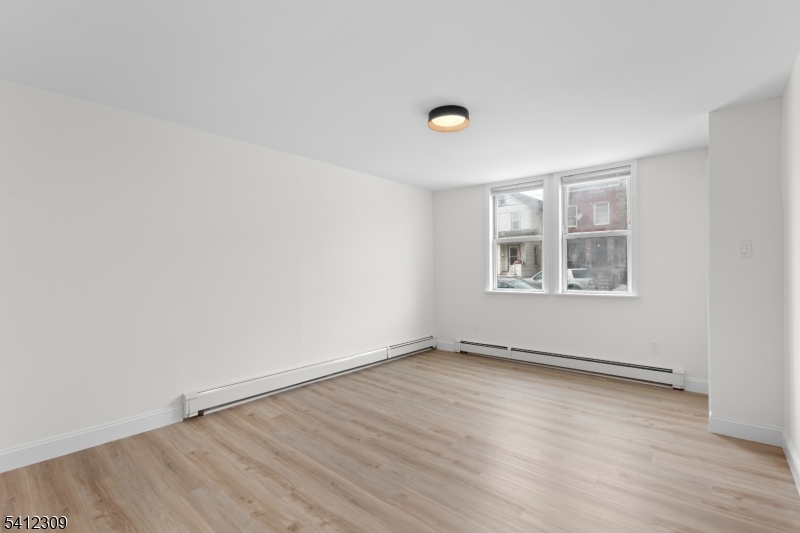 676 Chestnut Street, Unit 1 Kearny, NJ 07032 - Photo 5 of 27 an empty room with wooden floor and windows