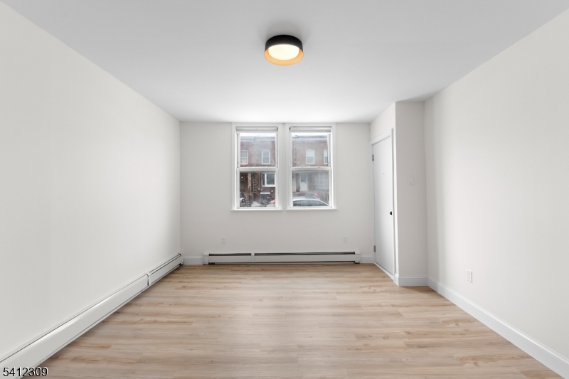 676 Chestnut Street, Unit 1 Kearny, NJ 07032 - Photo 6 of 27 an empty room with wooden floor and windows