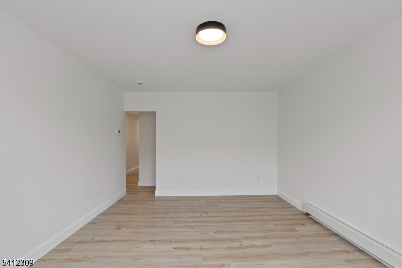 676 Chestnut Street, Unit 1 Kearny, NJ 07032 - Photo 9 of 27 a view of an empty room with wooden floor
