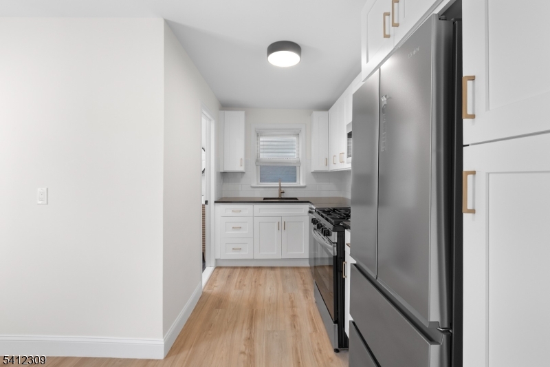 676 Chestnut Street, Unit 1 Kearny, NJ 07032 - Photo 10 of 27 a kitchen with a refrigerator and white cabinets