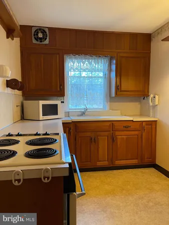a kitchen with a stove a sink and a cabinets