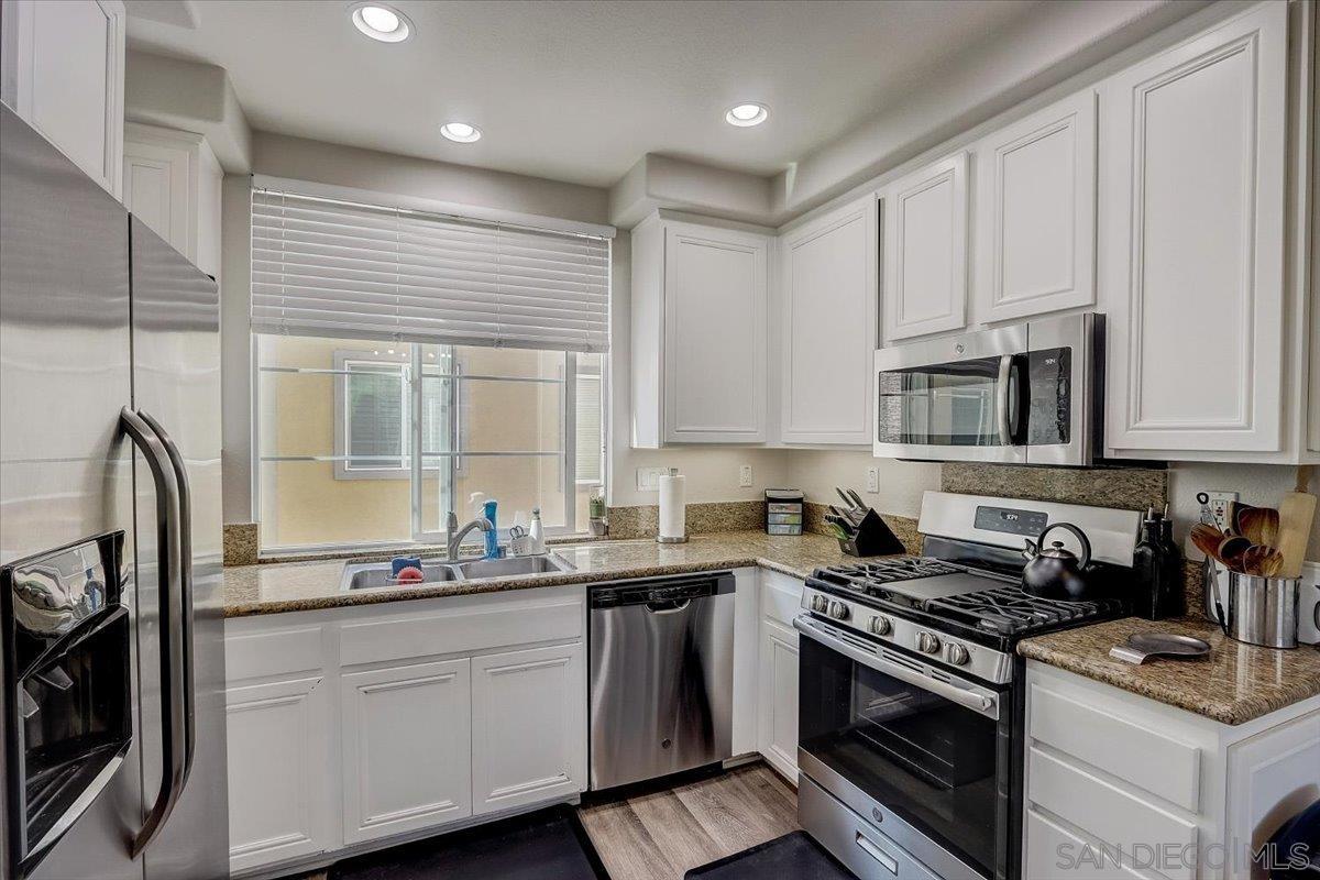 a kitchen with stainless steel appliances white cabinets and a stove a sink