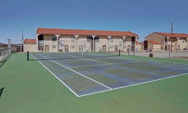 a view of tennis court with seating area